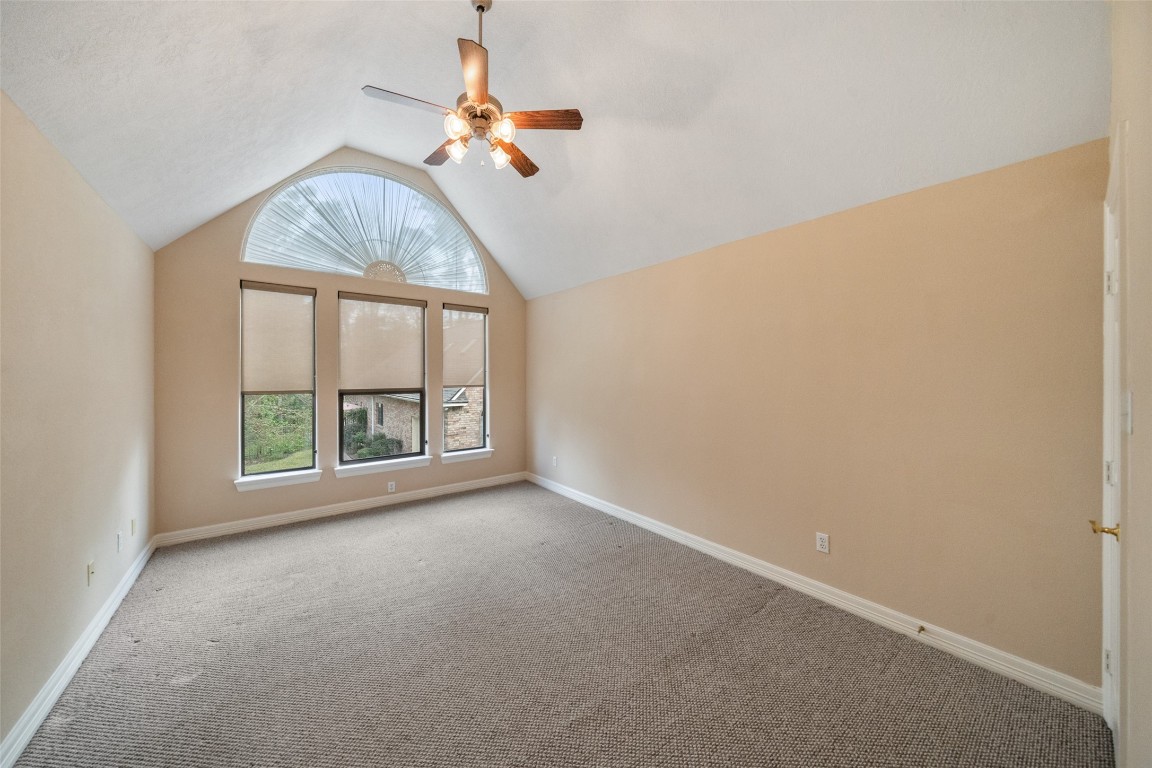 901 Longmire Road, Unit 28 Conroe, TX 77304 - Photo 28 of 31 an empty room with a chandelier fan and windows