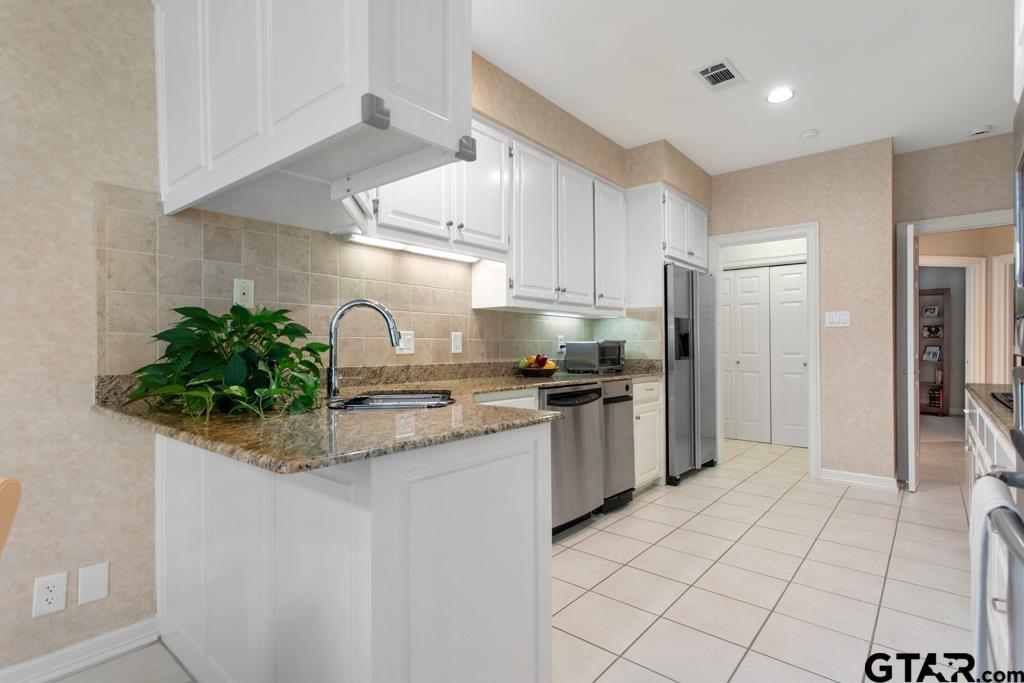 4608 North O'Connor Road Irving, TX 75062 - Photo 16 of 45 a kitchen with stainless steel appliances kitchen island granite countertop a sink a stove and a refrigerator