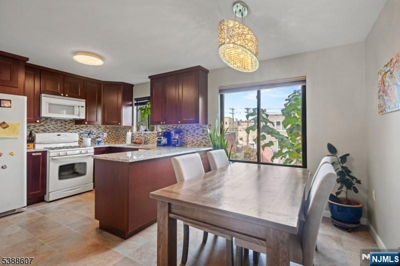 404-406 Chestnut Street Newark, NJ 07105 - Photo 13 of 27 a kitchen with stainless steel appliances granite countertop a stove a refrigerator a oven a sink a dining table and chairs with wooden floor