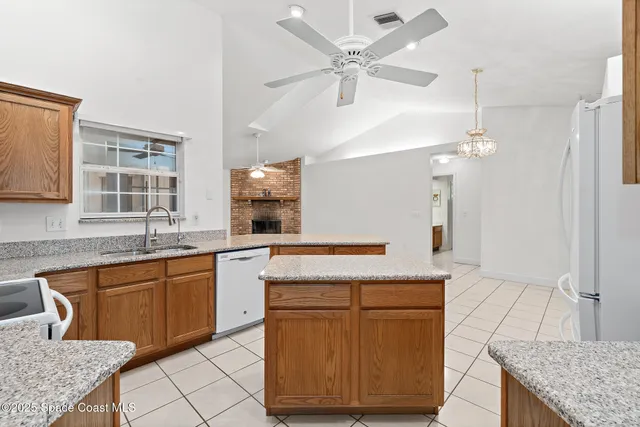 a view of an empty room with window and chandelier fan