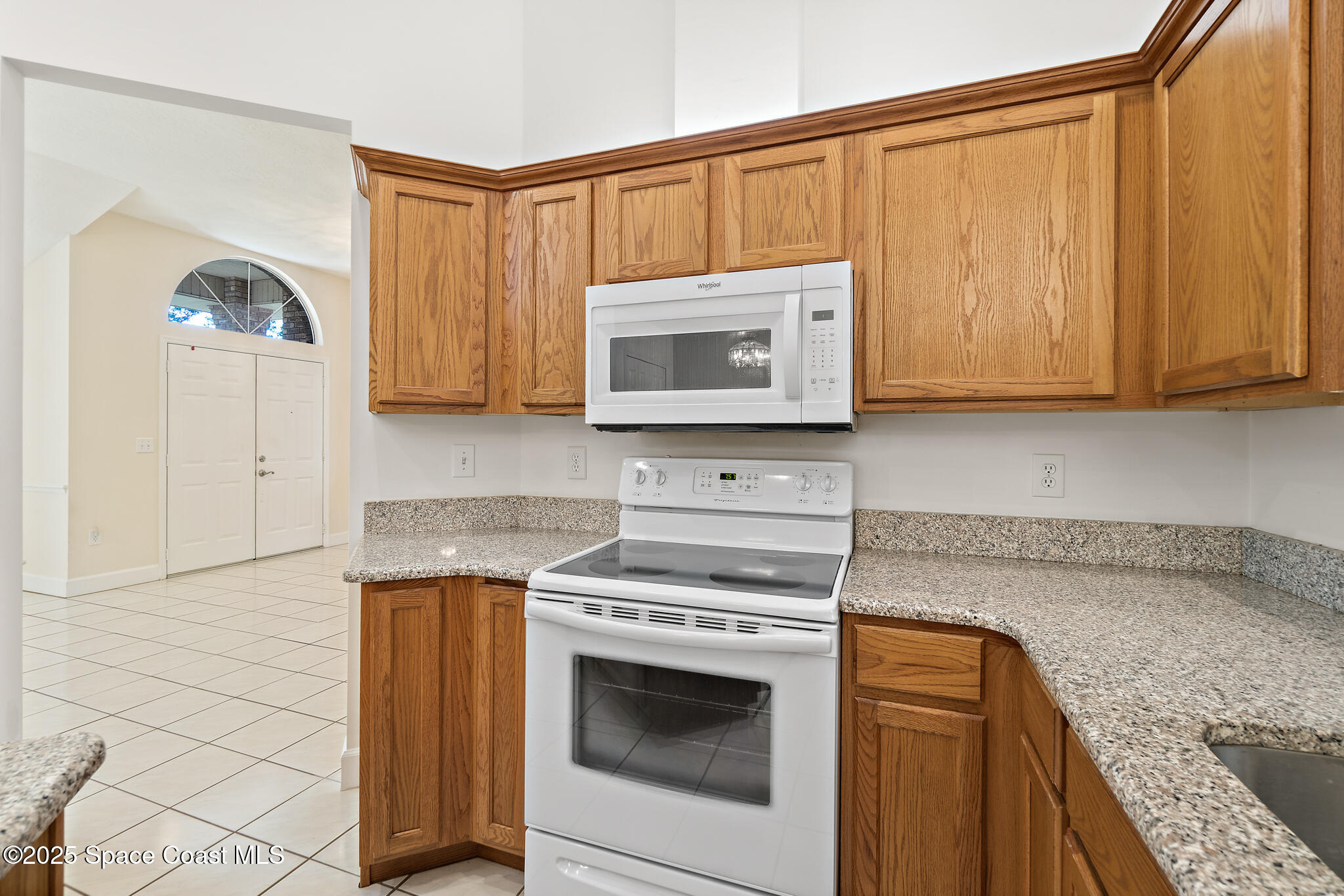 427 Hurst Road Northeast Palm Bay, FL 32907 - Photo 24 of 81 a kitchen with granite countertop a stove top oven microwave and cabinets