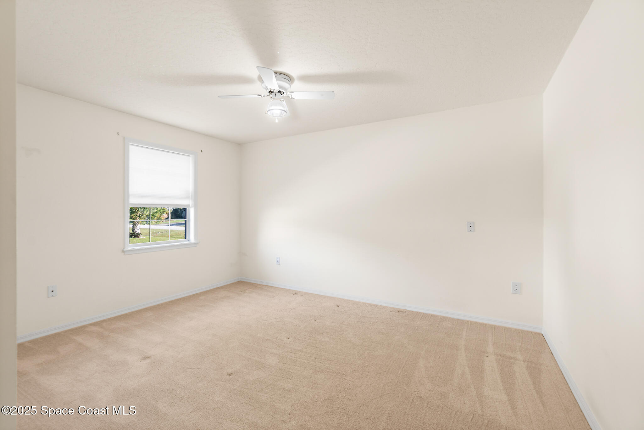 427 Hurst Road Northeast Palm Bay, FL 32907 - Photo 43 of 81 an empty room with a window and a fan