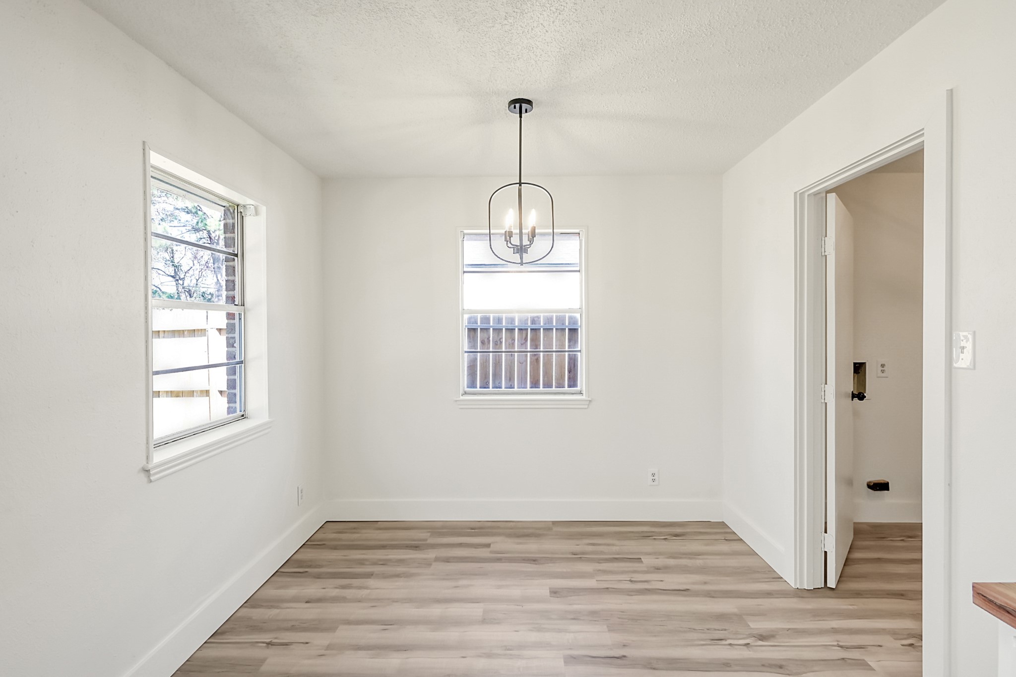 29615 Brookchase Drive Spring, TX 77386 - Photo 13 of 24 Bright dining area with light wood flooring, a modern pendant light, and two windows offering natural light. Neutral walls provide a clean and open feel.