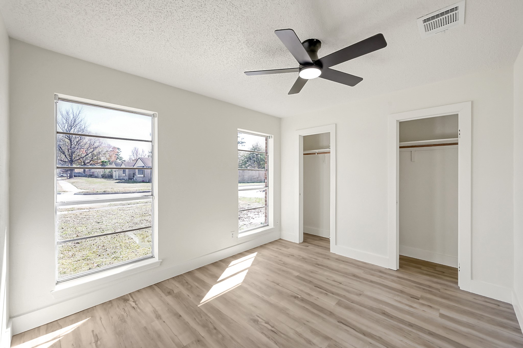 29615 Brookchase Drive Spring, TX 77386 - Photo 21 of 24 Bright and airy secondary bedroom featuring large windows, a modern ceiling fan, and two closets. The space has neutral color palette, ideal for personalization. Faces the front of the home.