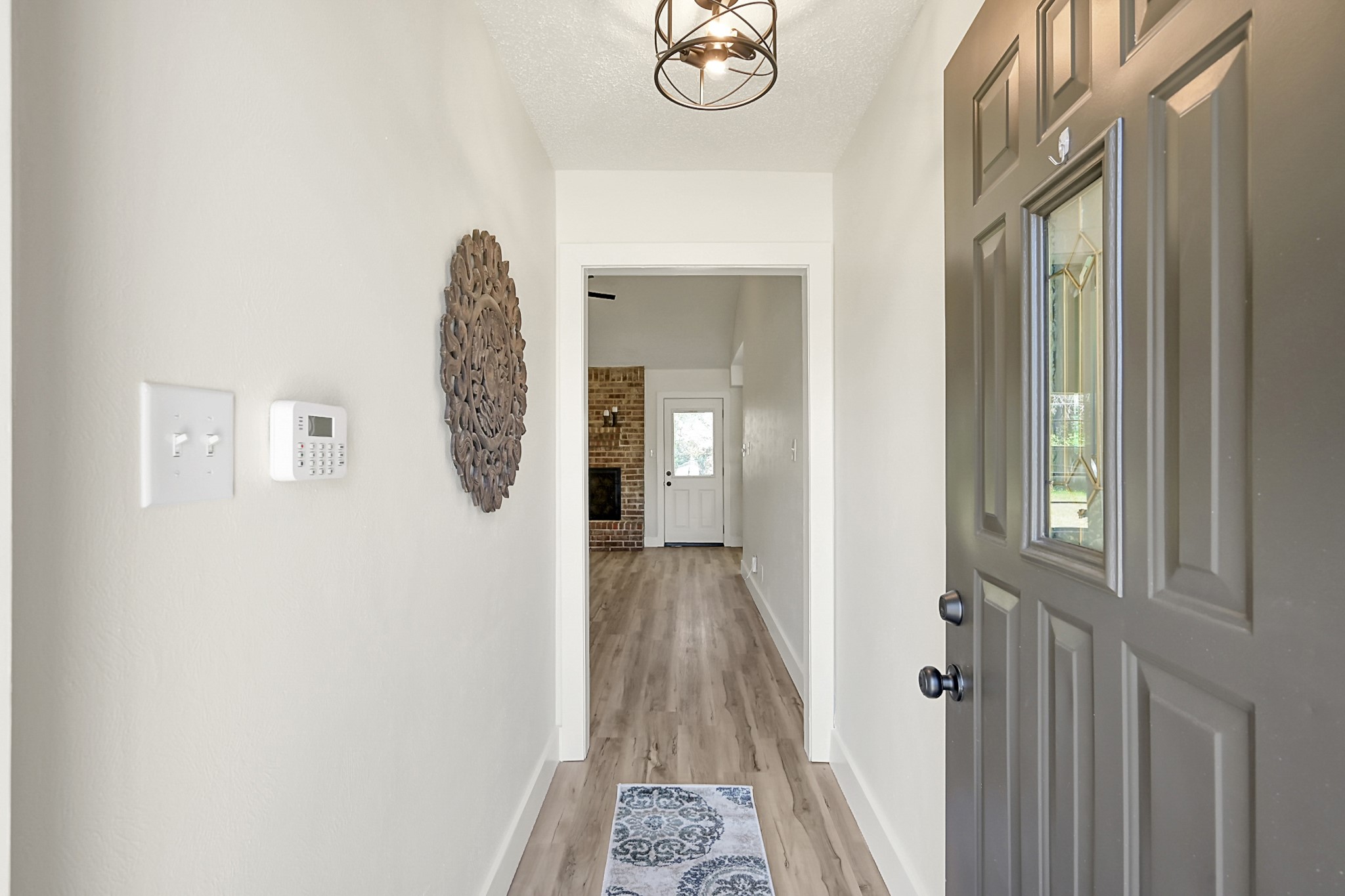 29615 Brookchase Drive Spring, TX 77386 - Photo 4 of 24 The entryway features a welcoming atmosphere. It leads into a bright living area with a glimpse of a brick fireplace, enhancing the home's cozy appeal.