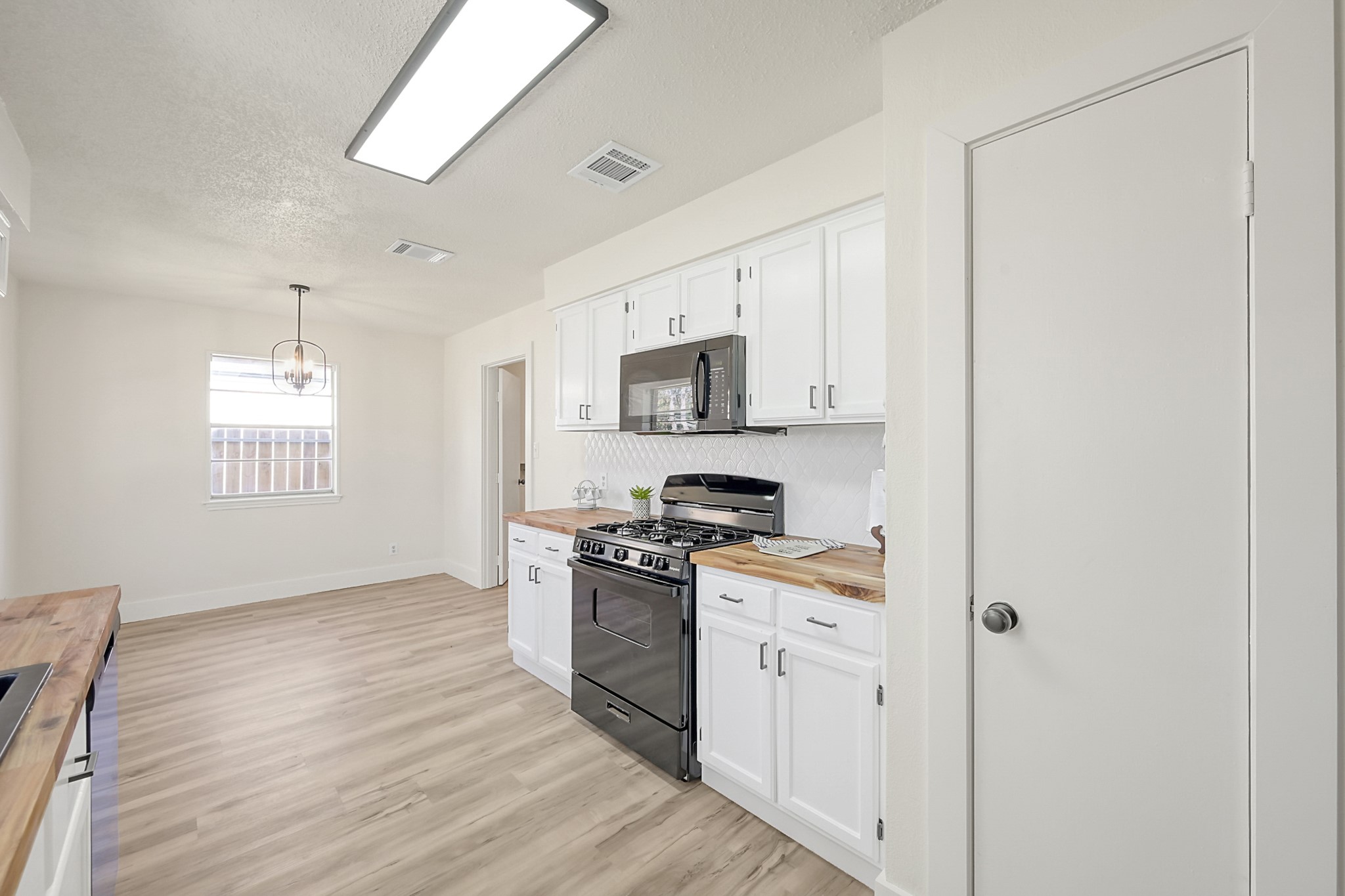 29615 Brookchase Drive Spring, TX 77386 - Photo 8 of 24 Bright, modern kitchen with white cabinetry, 2026 brand new appliances, and butcherblock countertops. This space creates an inviting and functional cooking area.