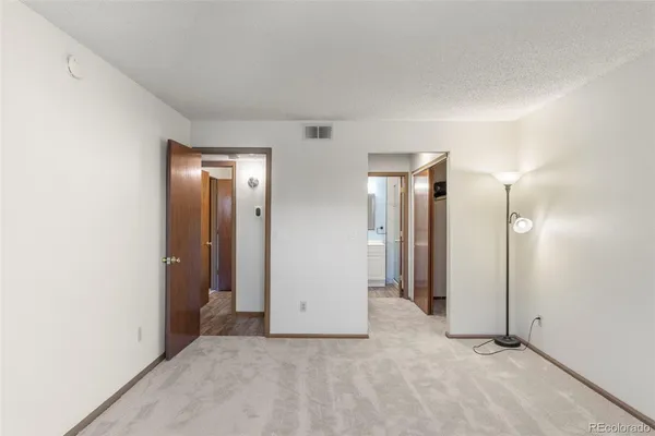 an empty room with closet and mirror