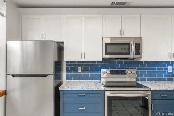 a kitchen with appliances a microwave and cabinets