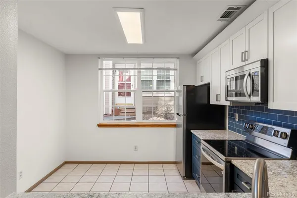 a kitchen with stainless steel appliances granite countertop a stove a microwave and a refrigerator