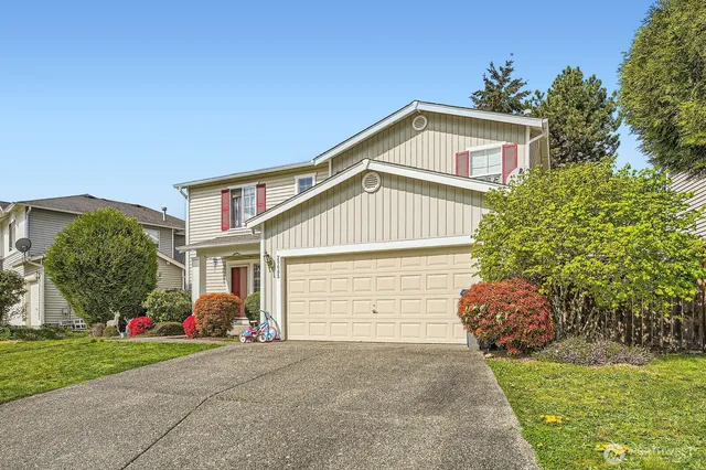 a front view of a house with a yard and garage