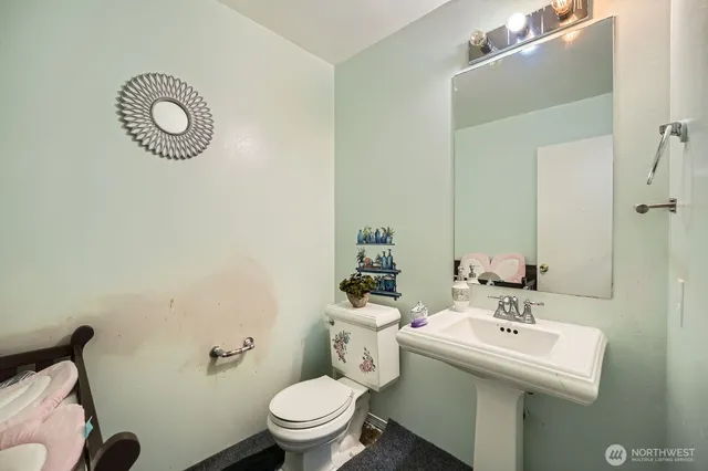 a bathroom with a sink toilet and a mirror