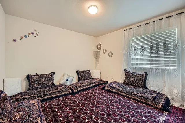 a bedroom with bed and wooden floor
