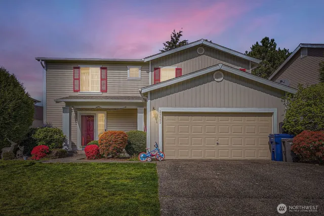 a front view of a house with a yard and garage