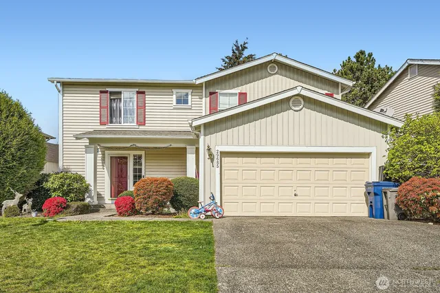 a front view of a house with a yard and garage