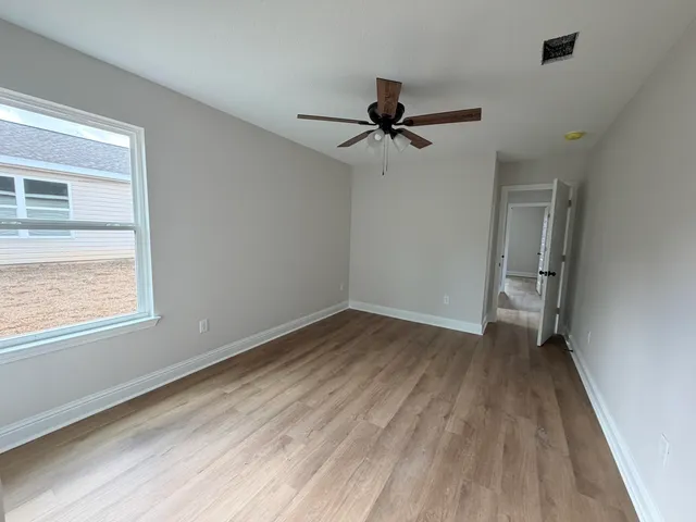 a view of room with hardwood floor and a ceiling fan