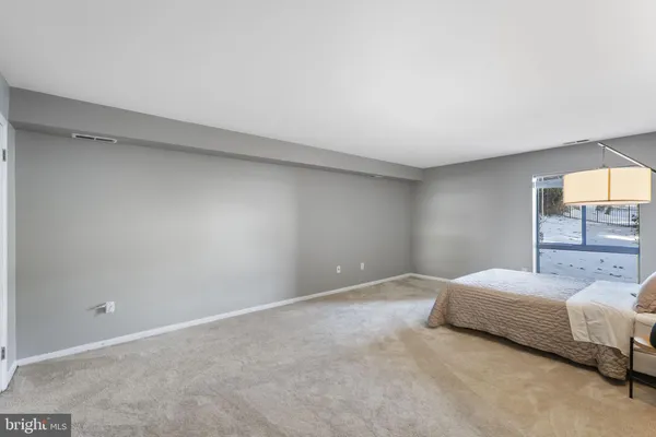 a bedroom with a bed and painting on the wall