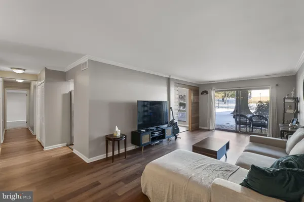 a living room with furniture wooden floor and a flat screen tv
