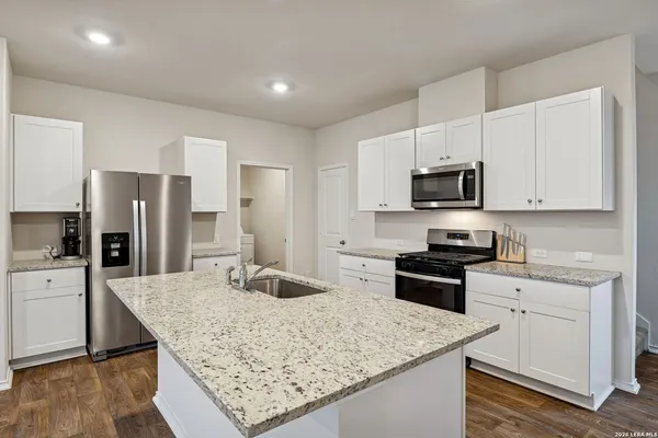 a kitchen with stainless steel appliances granite countertop a sink stove microwave and refrigerator