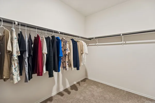 a view of walk in closet with clothes