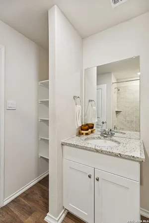 a bathroom with a granite countertop sink and a mirror