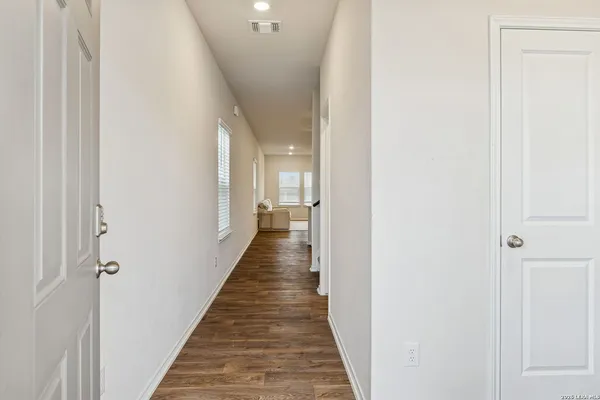 a hallway with wooden floor and staircase