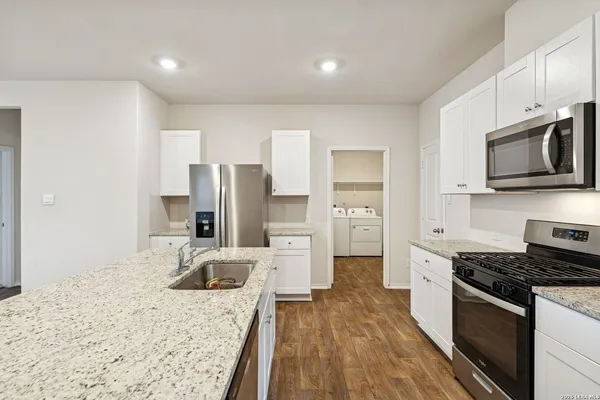 a kitchen with stainless steel appliances granite countertop a sink dishwasher stove and refrigerator