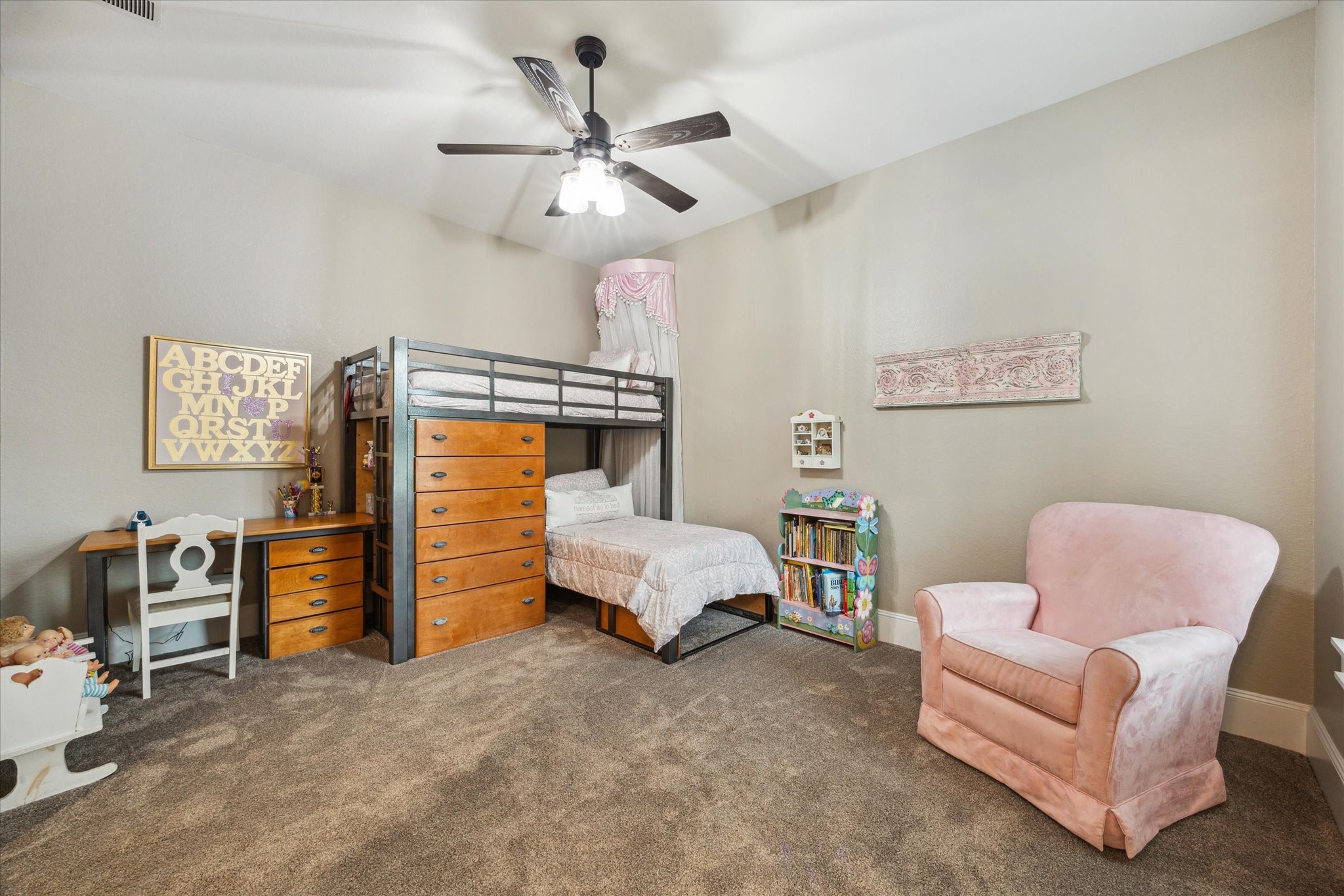 1255 Bronco Trail Angleton, TX 77515 - Photo 21 of 50 Bedroom two is generously sized, featuring soft, plush carpeting that adds warmth and comfort. The room includes a spacious walk-in closet for ample storage, and the 10-foot ceilings create an open, airy atmosphere, making it a perfect retreat or guest suite.
