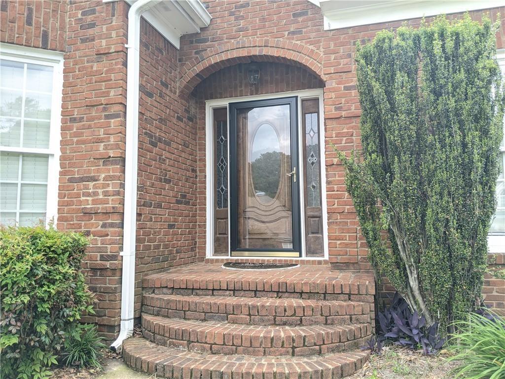 115 Parkview Trace Pass Southwest Lilburn, GA 30047 - Photo 2 of 19 a front view of a house with a garden