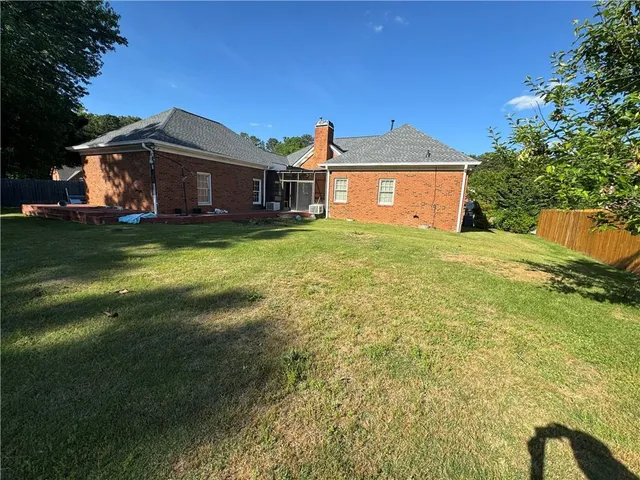 a view of a yard in front of a house with a large tree