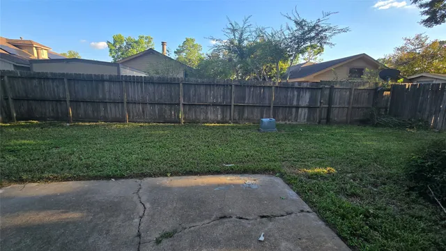 a view of a backyard with wooden fence