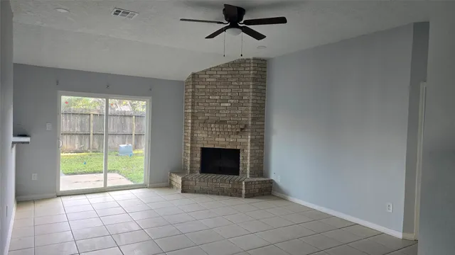a view of an empty room with a fireplace and a window