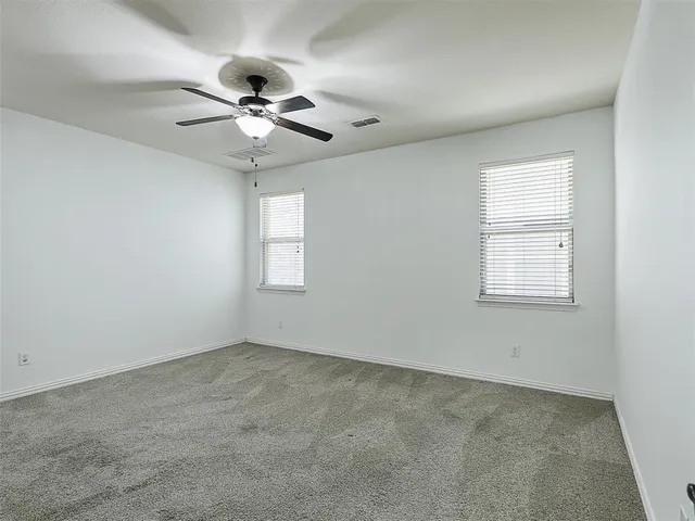 an empty room with a window and a fan