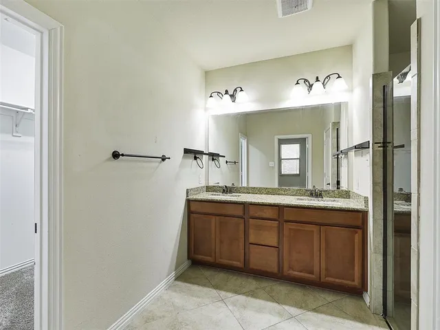 a spacious bathroom with a double vanity sink and a mirror
