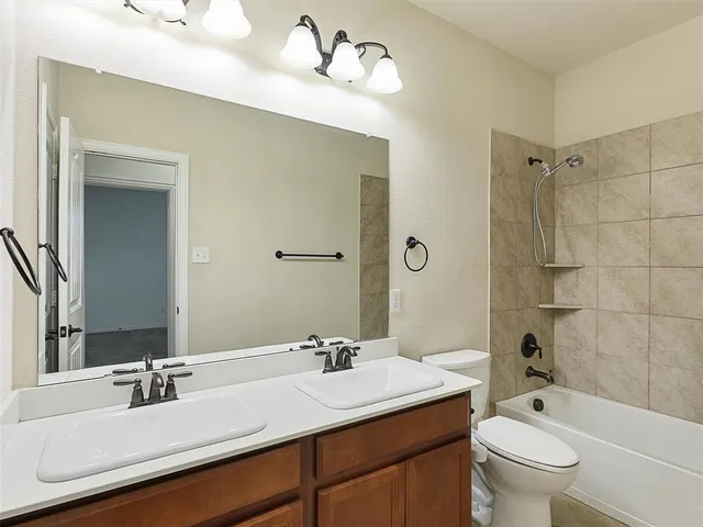 a bathroom with a double vanity sink toilet mirror and bathtub