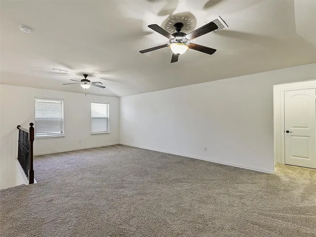 an empty room with fan and windows