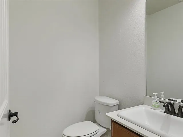 a white toilet sitting next to a white sink and vanity