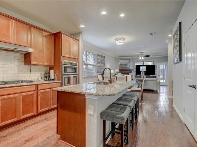 a kitchen with stainless steel appliances granite countertop wooden cabinets a sink and a stove