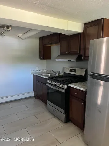 a kitchen with stainless steel appliances granite countertop a stove a refrigerator and a sink