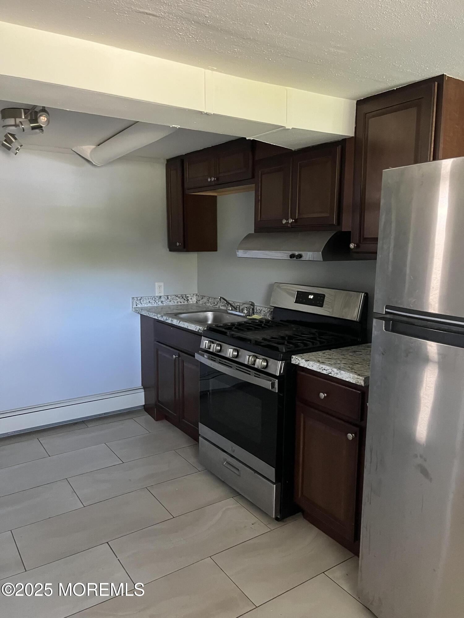 a kitchen with stainless steel appliances granite countertop a stove a refrigerator and a sink