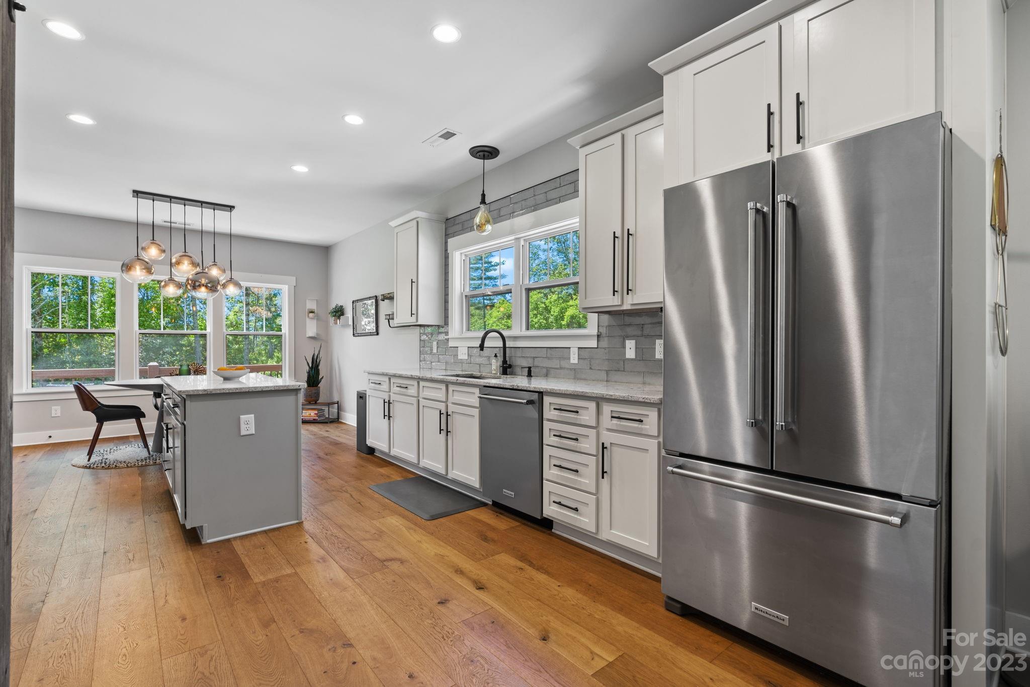 44 Reta Road Fairview, NC 28730 - Photo 14 of 36 a kitchen with stainless steel appliances a refrigerator sink and wooden floor