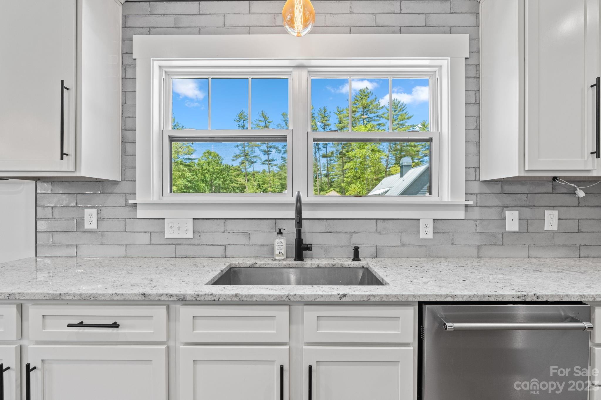 44 Reta Road Fairview, NC 28730 - Photo 15 of 36 a kitchen with granite countertop a sink window and cabinets
