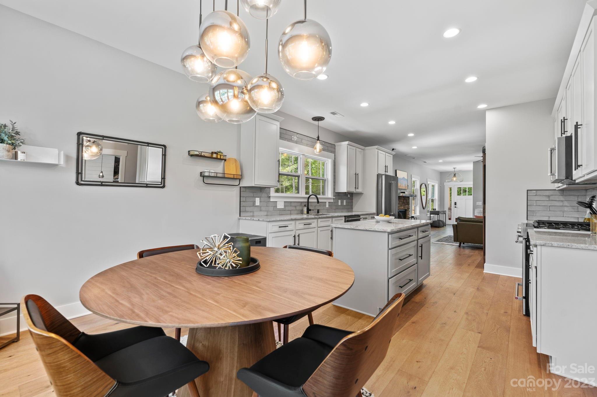 44 Reta Road Fairview, NC 28730 - Photo 17 of 36 a kitchen with stainless steel appliances granite countertop a dining table chairs and a refrigerator