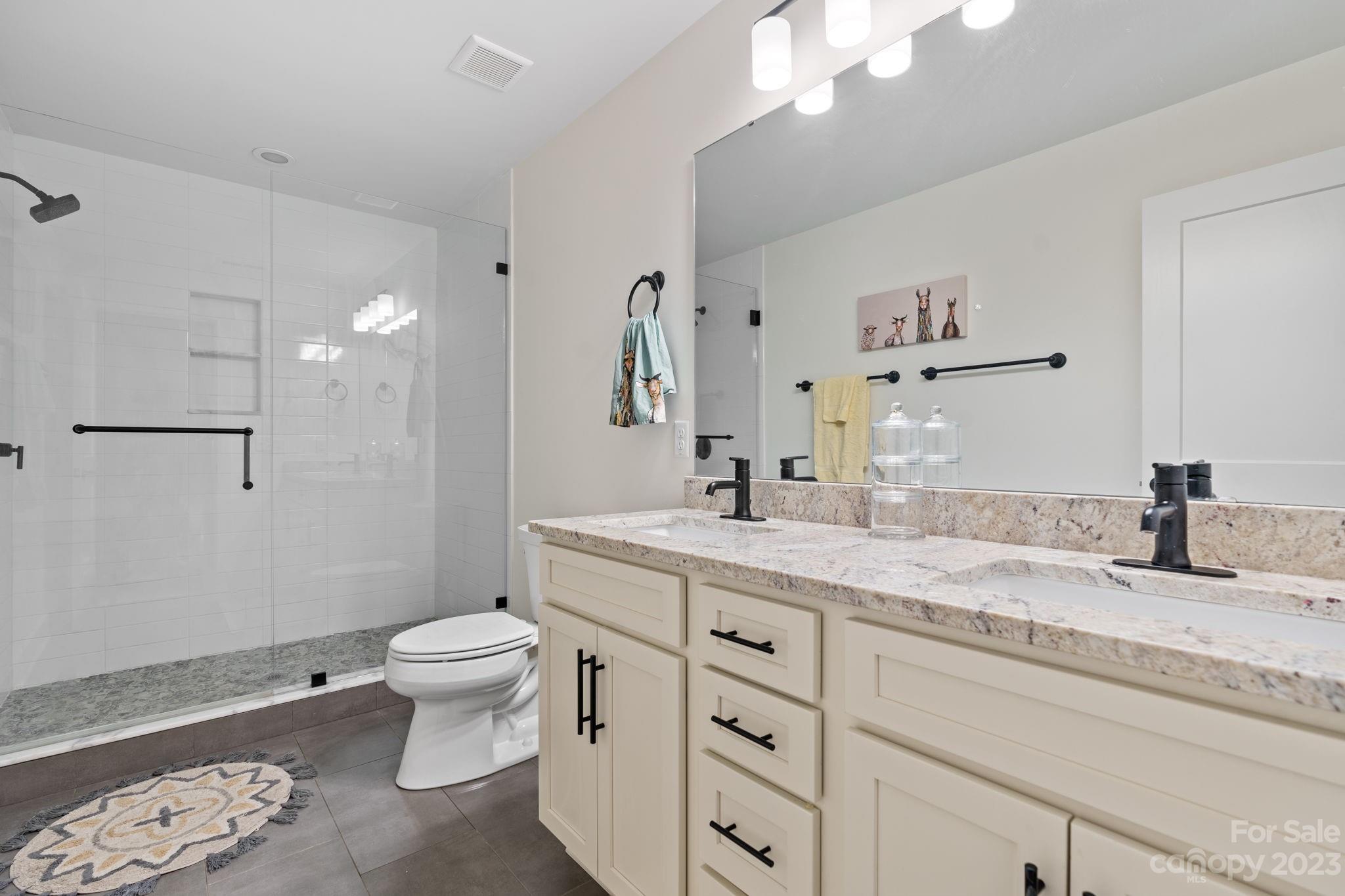 44 Reta Road Fairview, NC 28730 - Photo 25 of 36 a bathroom with a granite countertop sink a toilet and a mirror