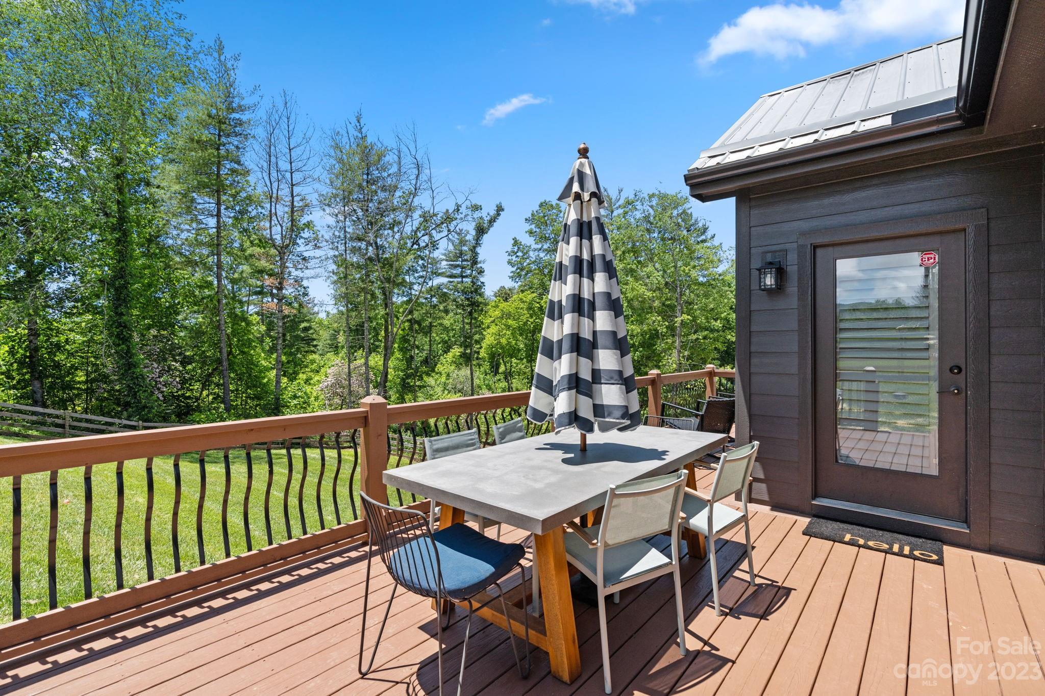 44 Reta Road Fairview, NC 28730 - Photo 5 of 36 a view of a patio with table and chairs with wooden floor and fence