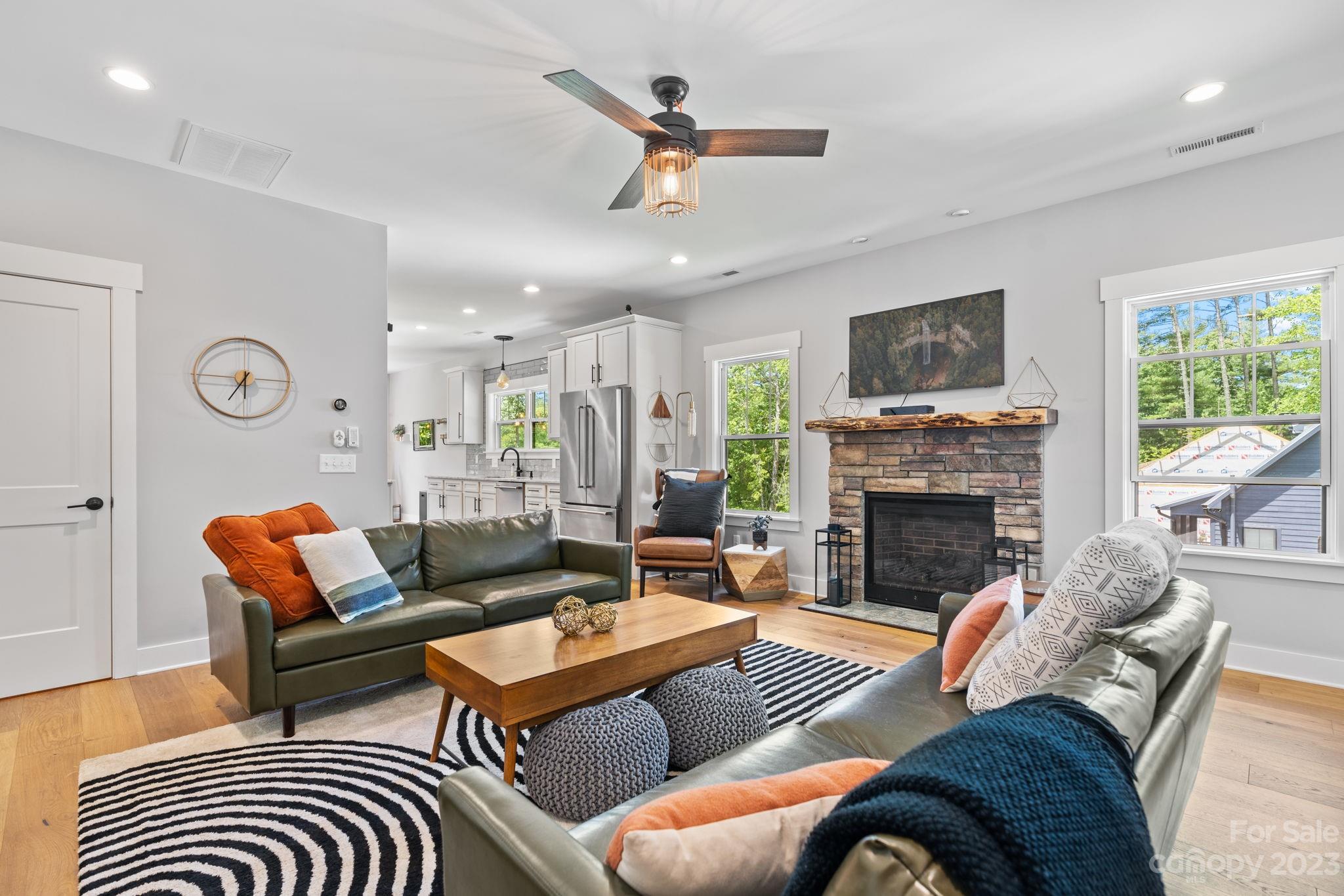 44 Reta Road Fairview, NC 28730 - Photo 10 of 36 a living room with furniture a fireplace and a flat screen tv