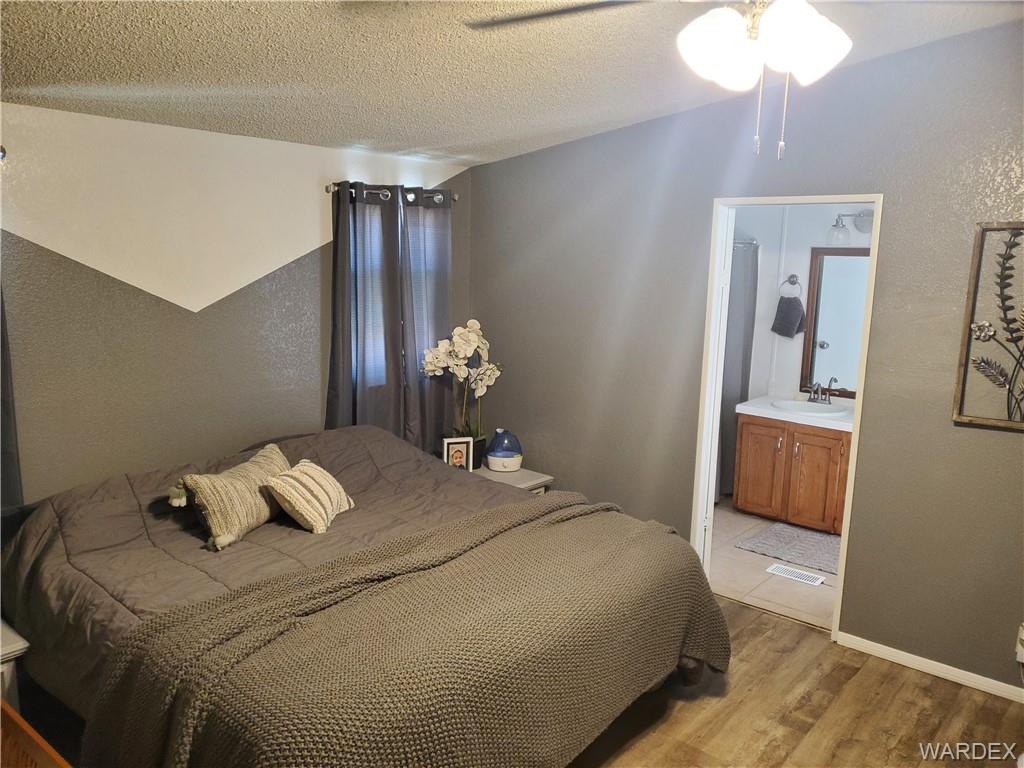 2277 Egar Road Golden Valley, AZ 86413 - Photo 13 of 28 a bedroom with a bed and a chandelier