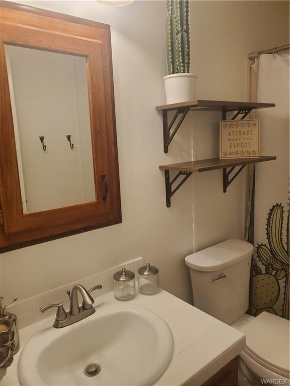 2277 Egar Road Golden Valley, AZ 86413 - Photo 18 of 28 a bathroom with a sink mirror and toilet