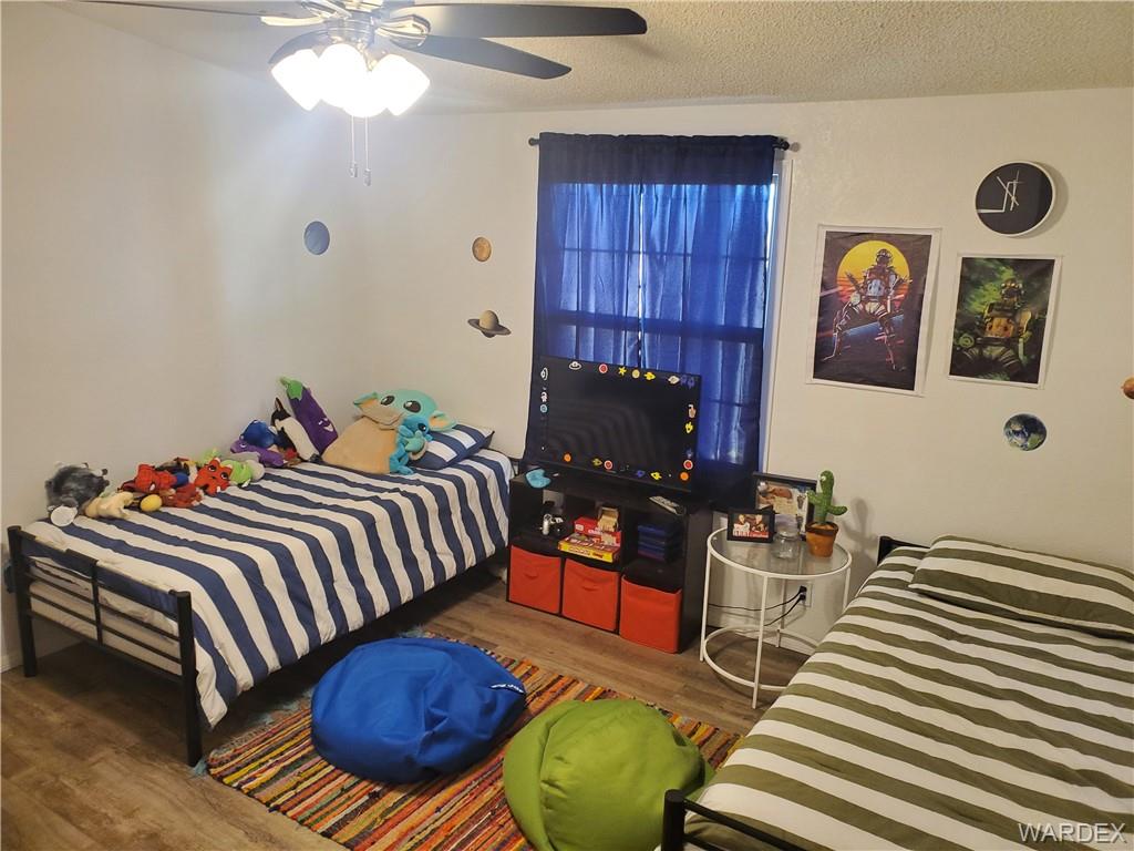 2277 Egar Road Golden Valley, AZ 86413 - Photo 23 of 28 a bedroom with a bed and wooden floor