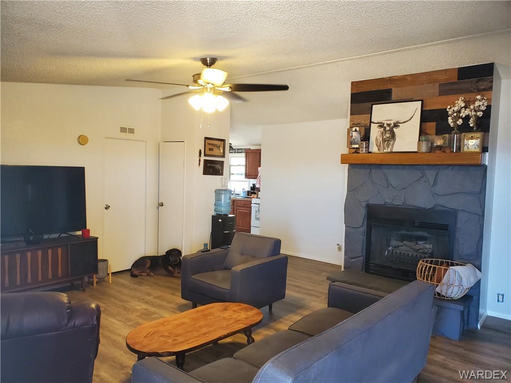 2277 Egar Road Golden Valley, AZ 86413 - Photo 3 of 28 a living room with furniture a flat screen tv and a fireplace