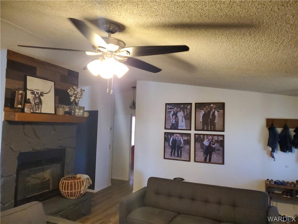 2277 Egar Road Golden Valley, AZ 86413 - Photo 6 of 28 a living room with furniture a chandelier and a fireplace